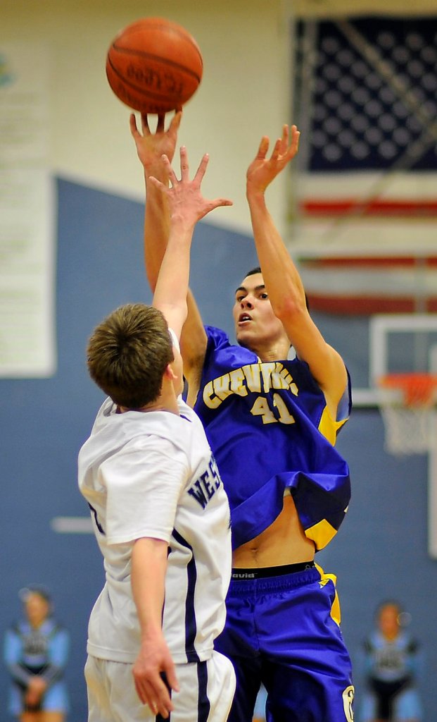 Louie DiStasio of Cheverus releases a 3-point attempt over Ian King of Westbrook. DiStasio had 12 of his 14 points in the first half to help the Stags take control on the way to a 52-35 win.