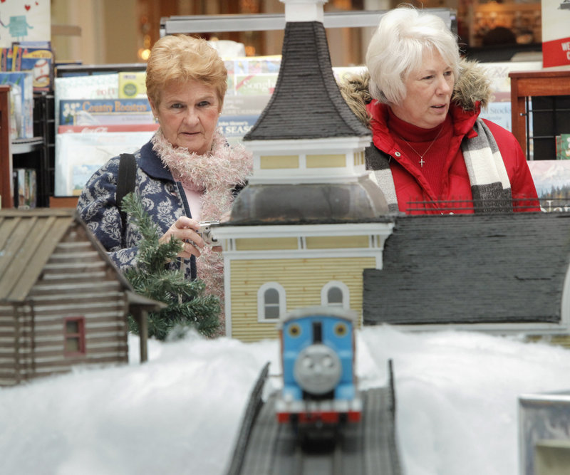Gail Domin of Old Orchard Beach, left, and Shari DeKoning of Scarborough look over the extensive train set-up at the Maine Mall on Wednesday. DeKoning reminisced about a train her brother got in 1948 – “I loved it,” she said.