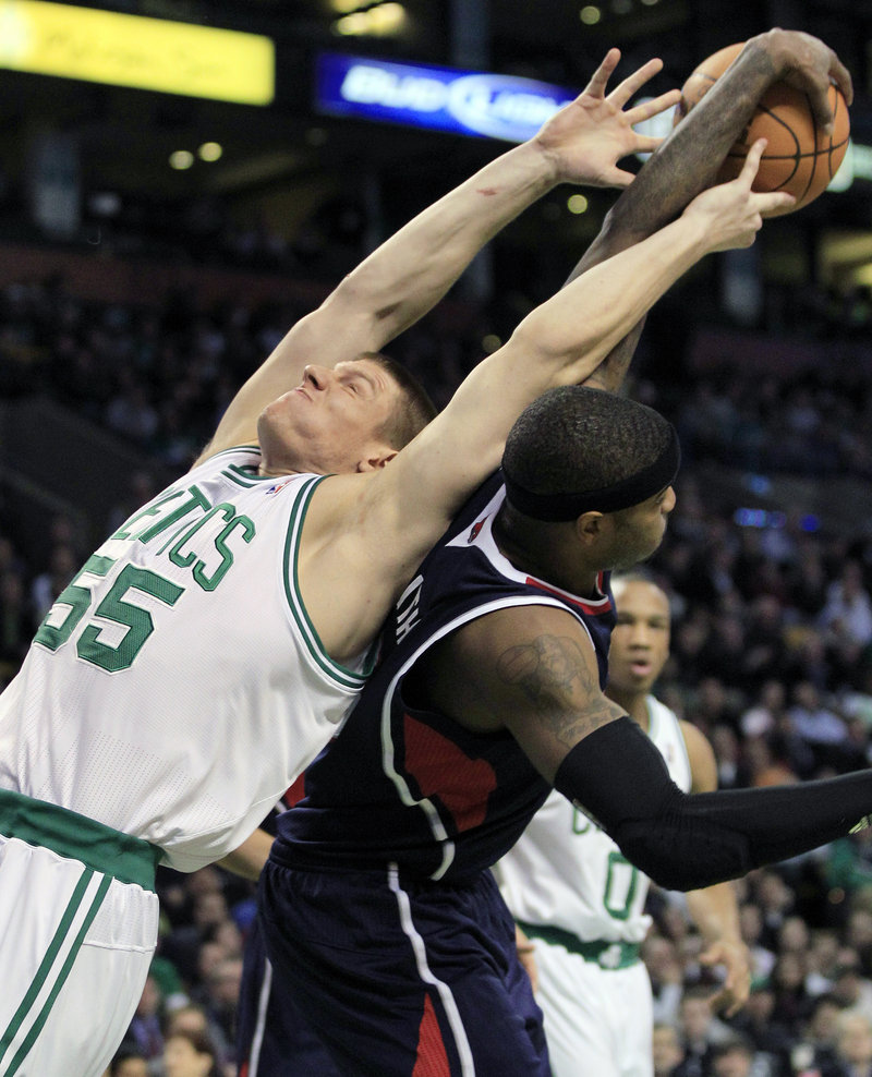 Luke Harangody of the Boston Celtics, left, gives it a stretch Thursday night but can’t get a rebound away from Josh Smith of the Atlanta Hawks. The Celtics won, 102-90.