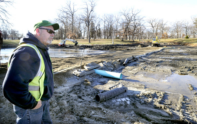 “It is all gross, but this is definitely going to be an improvement,” says Rick Meserve, supervisor of Portland Public Services, watching as mud is cleared from the Deering Oaks pond on Friday. The removal of the material will expose the pond’s original sandy bottom.