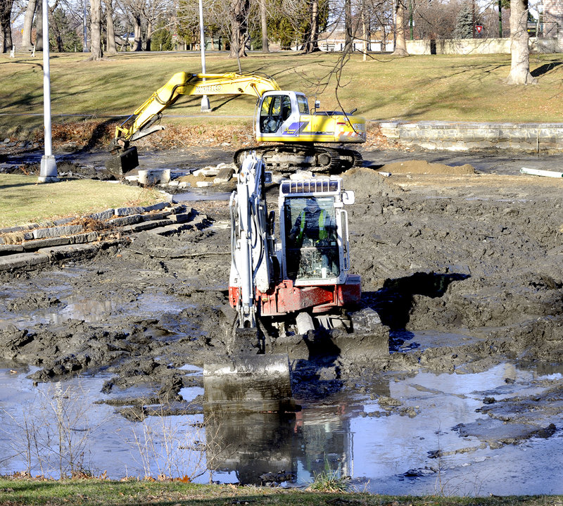 Crews from Portland Public Services use excavators to remove mud Friday from Deering Oaks pond. The project, which will continue next week, was planned to coincide with the annual draining of the water.