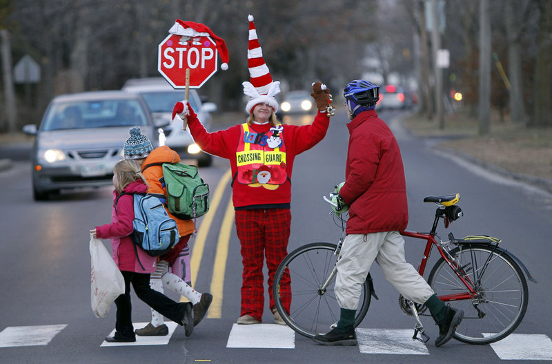 Crossing guard Lisa Green wears Christmas-inspired clothing as she brings the holiday spirit to her job Friday in Brunswick.