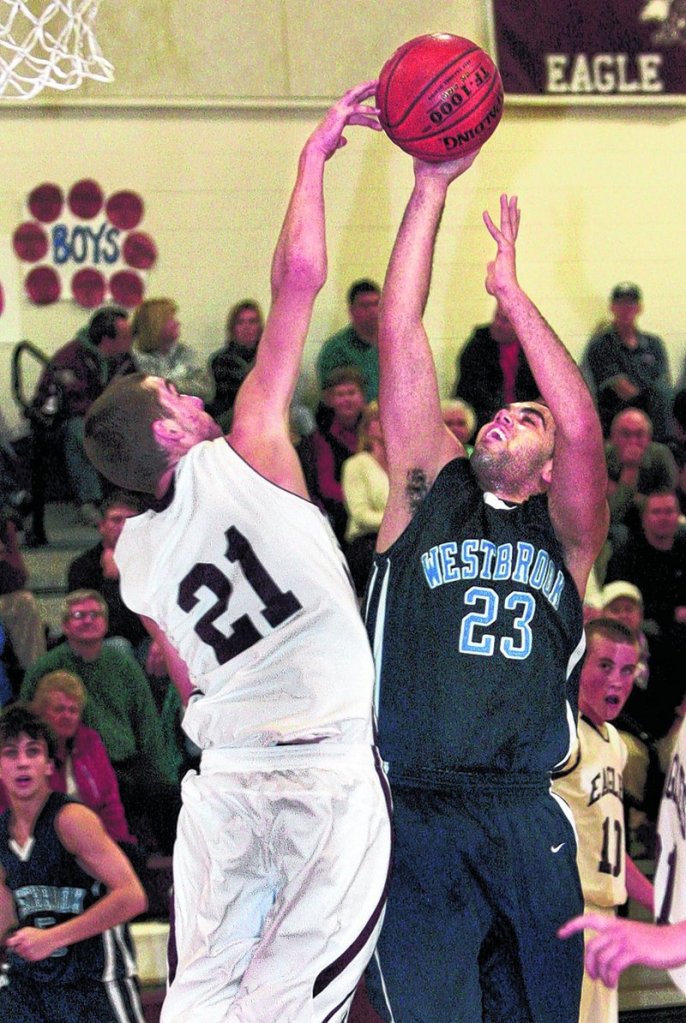 Jed Merrill, left, of Windham gets a hand on a shot by Edwin Grant of Westbrook in the second half of Westbrook s 61-50 victory Friday night, The Blazes led by 17 points in the second half, then had to hold off a late comeback.