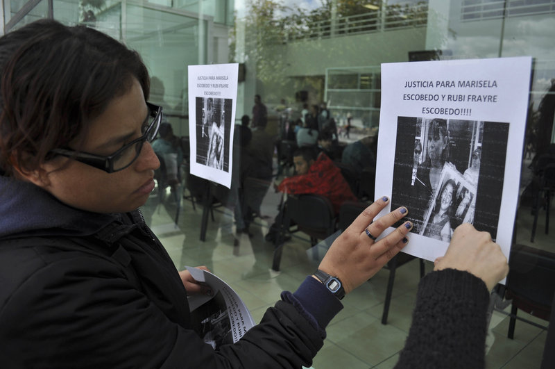 Human rights activists hang a sign on the wall of the state prosecutor’s office to protest the killing of Marisela Escobedo in Ciudad Juarez, Mexico, on Friday. Escobedo, was shot in the head Thursday as she protested the unpunished murder of her 16-year-old daughter.