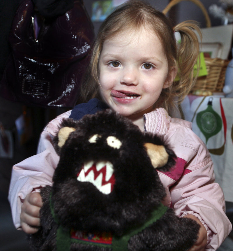 Gabriella Anderson, 2, of Scarborough holds her stuffed Bigfoot at Saturday's Handmade Holiday Craft Fair in Biddeford.