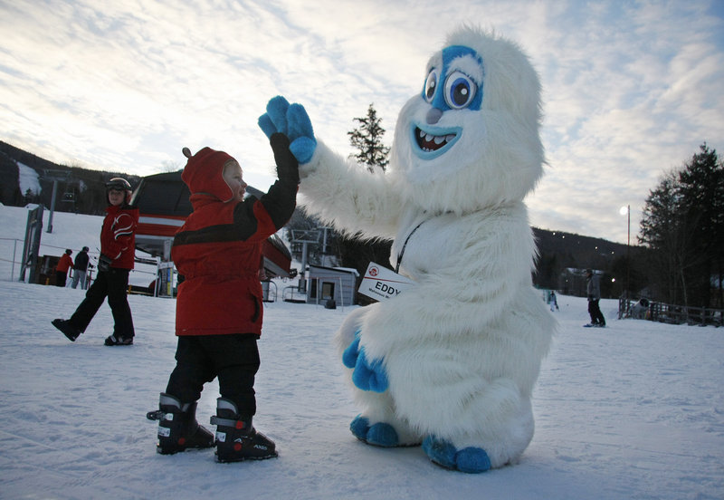 Ian Cushing, 2, of Franklin, Mass., gives Eddy the Yeti a high-five before going skiing for the first time during Winterfest on Saturday.
