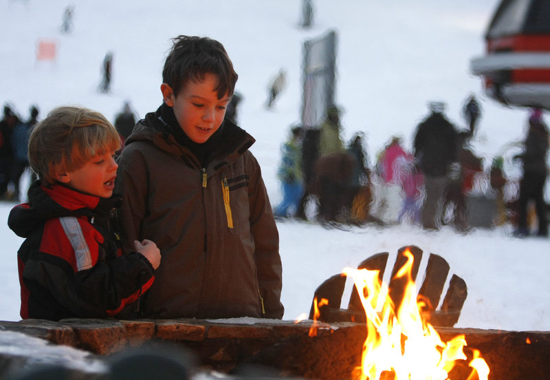 David, 5, and Peter Kane, 8, of Marblehead, Mass., warm up by the outdoor fire pit.