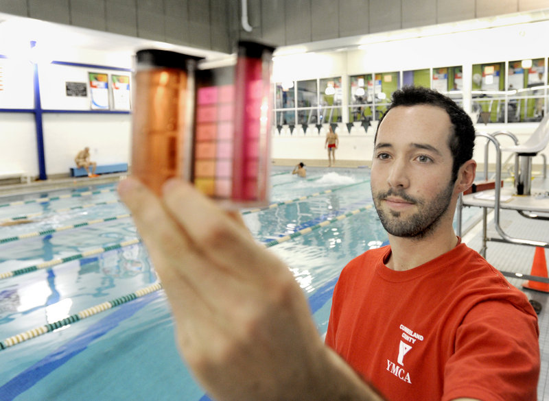 Graham Cavanagh, a lifeguard at the busy YMCA pool on Forest Avenue in Portland, tests the water's pH and chlorine levels. In the past year, the pool reduced the amount of chlorine it uses by 60 percent.
