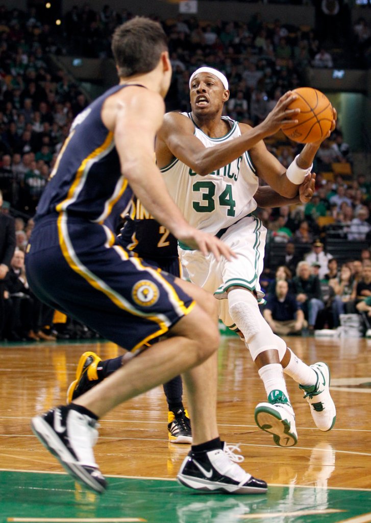 Paul Pierce passes the ball in front of the defense of Indiana’s Jeff Foster on Sunday. Pierce had his seventh career triple-double as the Celtics won 99-88.