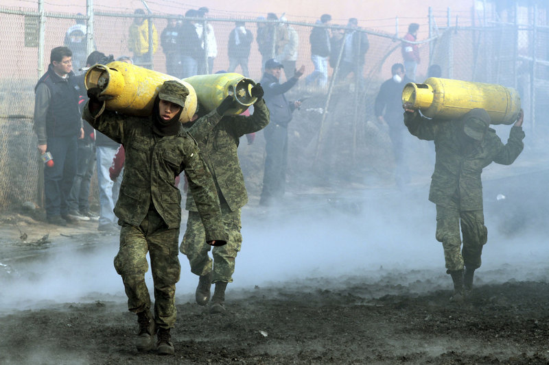 Mexican soldiers remove household gas tanks that survived the fires after a pipeline explosion Sunday in San Martin Texmelucan, Mexico. A pipeline run by the state-owned oil company exploded as thieves were trying to steal either gas or oil, authorities said.