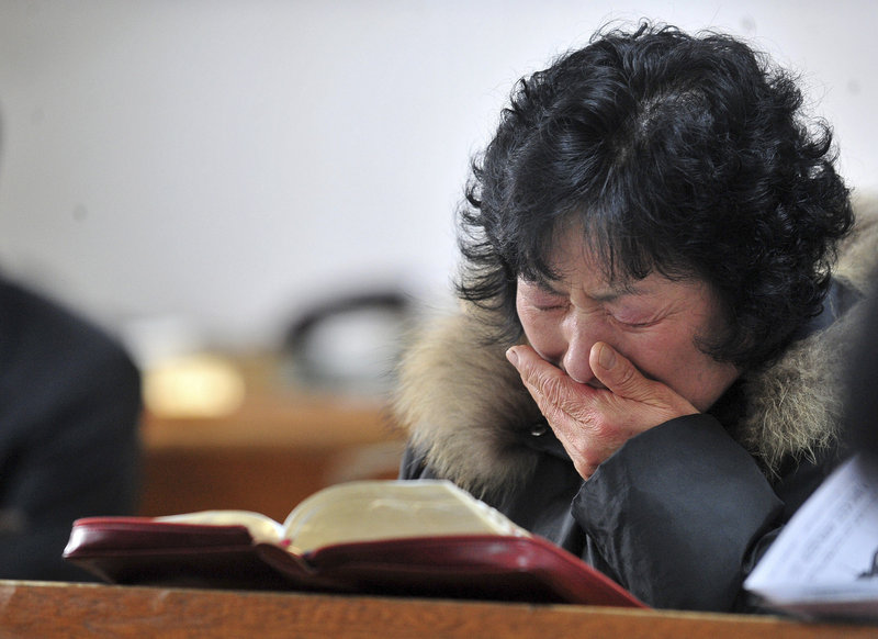 A resident cries during a church service on Yeonpyeong Island, South Korea, on Sunday. Residents were ordered to take shelter underground in advance of military exercises.