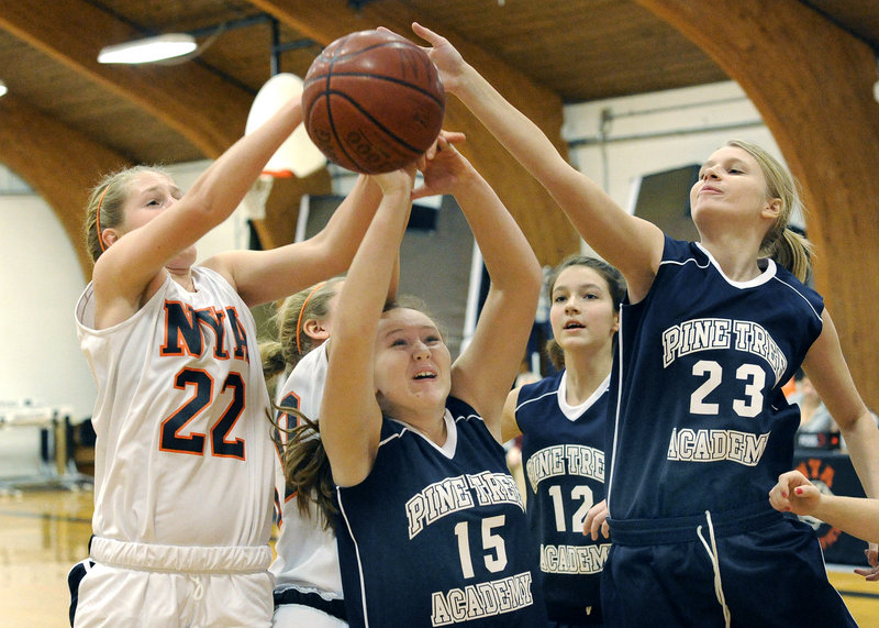 Morgan Scully, left, of North Yarmouth Academy battles for a rebound with Pine Tree Academy s Taylor Johnson, center, and Rebecca Moore-Myshall during NYA's 68-17 victory Monday afternoon.