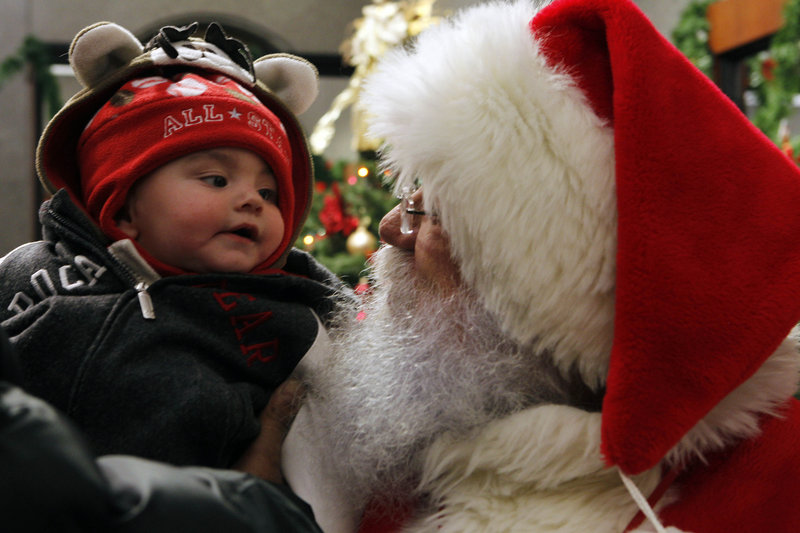 Seven-month-old Cameron Vegas checks out Santa John Wenner in Philadelphia Friday.