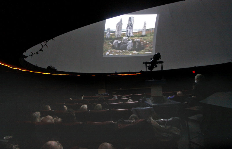 Patrick Peoples, right, shows a slide of neolithic stones at the University of Maine’s Southworth Planetarium on Monday night. Peoples’ subject was “Mid Winter’s Eve at Stonehenge,” but his lecture ranged beyond the famed English monument to include other sites in the British Isles and France.
