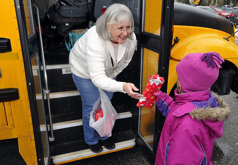 Grace Cole, bus driver for Hall Elementary School in Portland, makes mittens for her passengers every year. Here she gives a pair to Jada Briley, 7, a regular rider who was riding home with her mother on Wednesday.