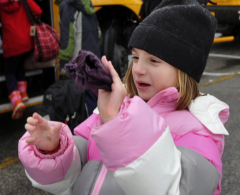 Faith Longval, 8, expresses her joy over the color of the mittens she received from bus driver Grace Cole. Cole says she tries to match the hue of the mittens with the children’s coats.