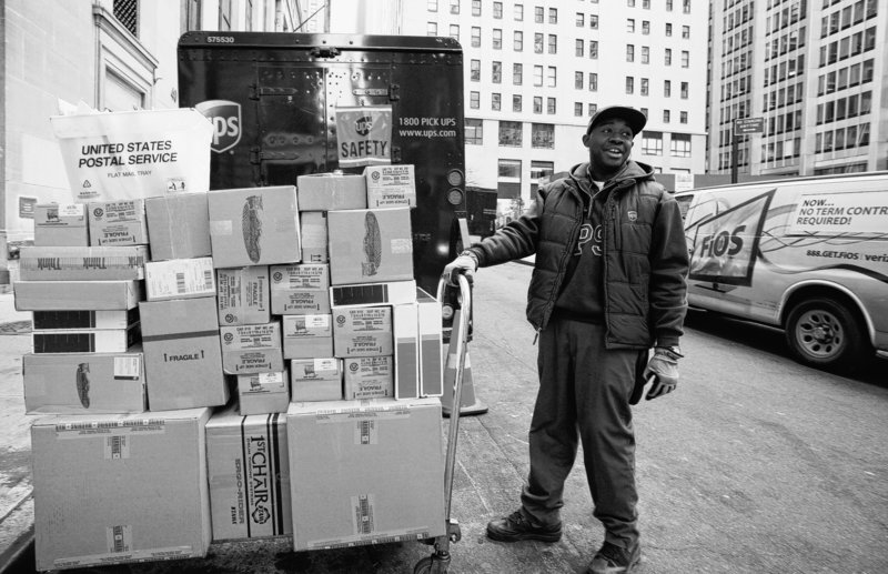 UPS driver Troy Cutkelvin pulls a cart of boxes as he makes his rounds Wednesday in New York. The company expected to deliver a record 24 million shipments worldwide in 24 hours.