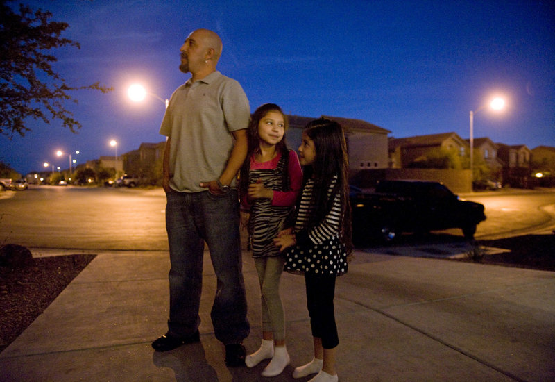 Justin Sanchez, a father of three who used to make $100,000 a year as a carpenter but is now out of work, stands outside his Las Vegas home with daughters Janelle, 8, and Lily, 6, after finding out that his family had three days to vacate their home because of foreclosure. He recently talked to a recruiter about a trucking job in Colorado.