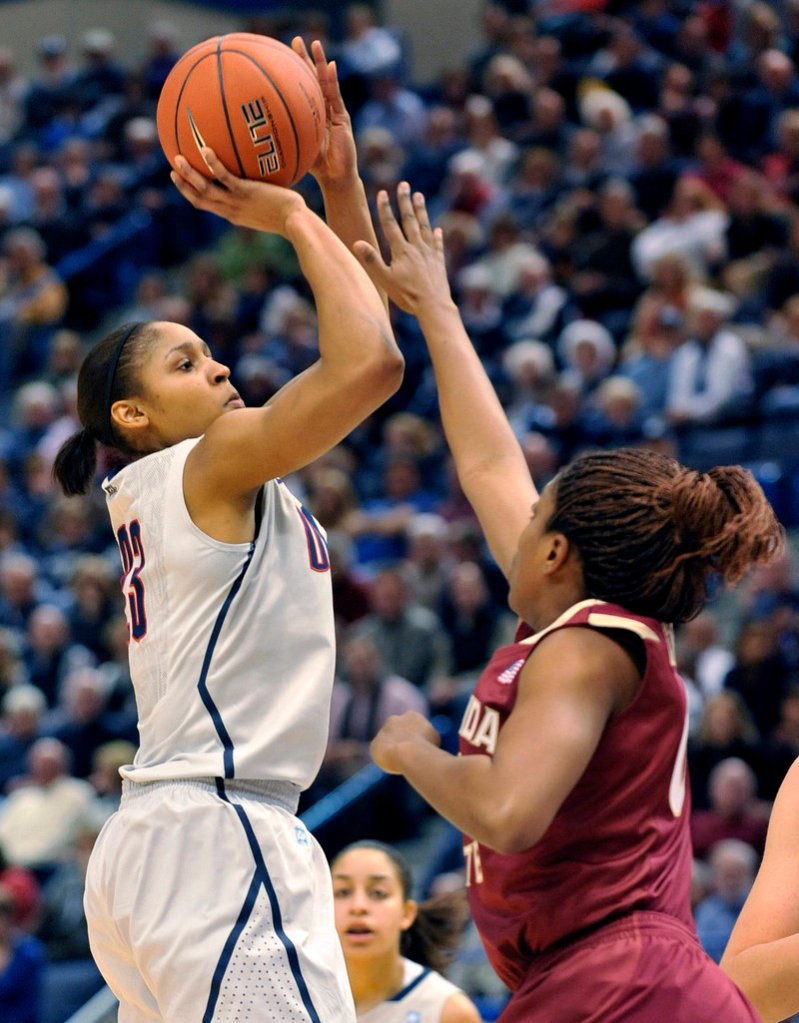 University of Connecticut forward Maya Moore shoots over Florida State forward Chasity Clayton during an NCAA game on Tuesday. Connecticut’s win broke a long-held record – a feat barely acknowledged by the media and raising questions about support for women’s sports.