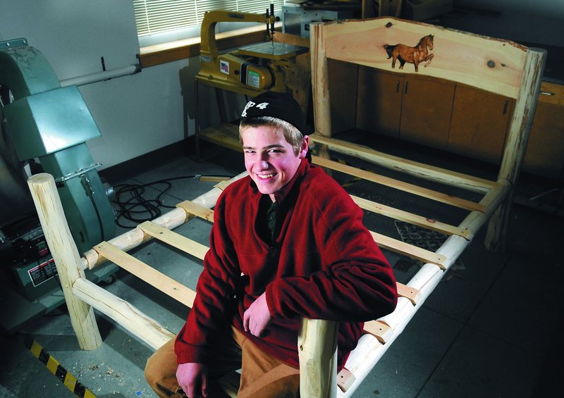 Gary “Wes” Boynton, an eighth-grader at Maranacook Community Middle School, sits on a bed he made from logs. He plans to give the bed to his teacher’s daughter for Christmas.