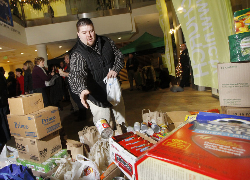Robert Bisson of Rochester, N.H., drops off canned goods Thursday at a Christmas celebration hosted by the Next Level Church at the University of Southern Maine’s Abromson Center. The church, a new Christian congregation in Portland, expected to collect up to 10,000 pounds of nonperishable food items for the Wayside Food Rescue Program.