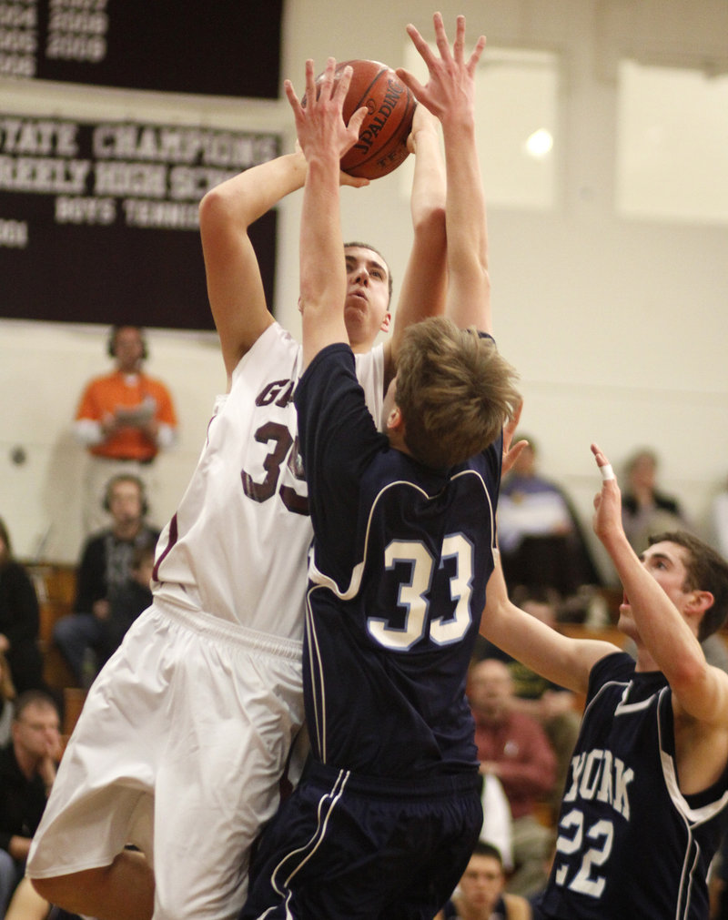 Michael McDevitt of Greely finds just enough room to shoot Thursday night while guarded by Hayden Webster, 33, and Michael King of York during Greely's 67-49 victory at Cumberland.