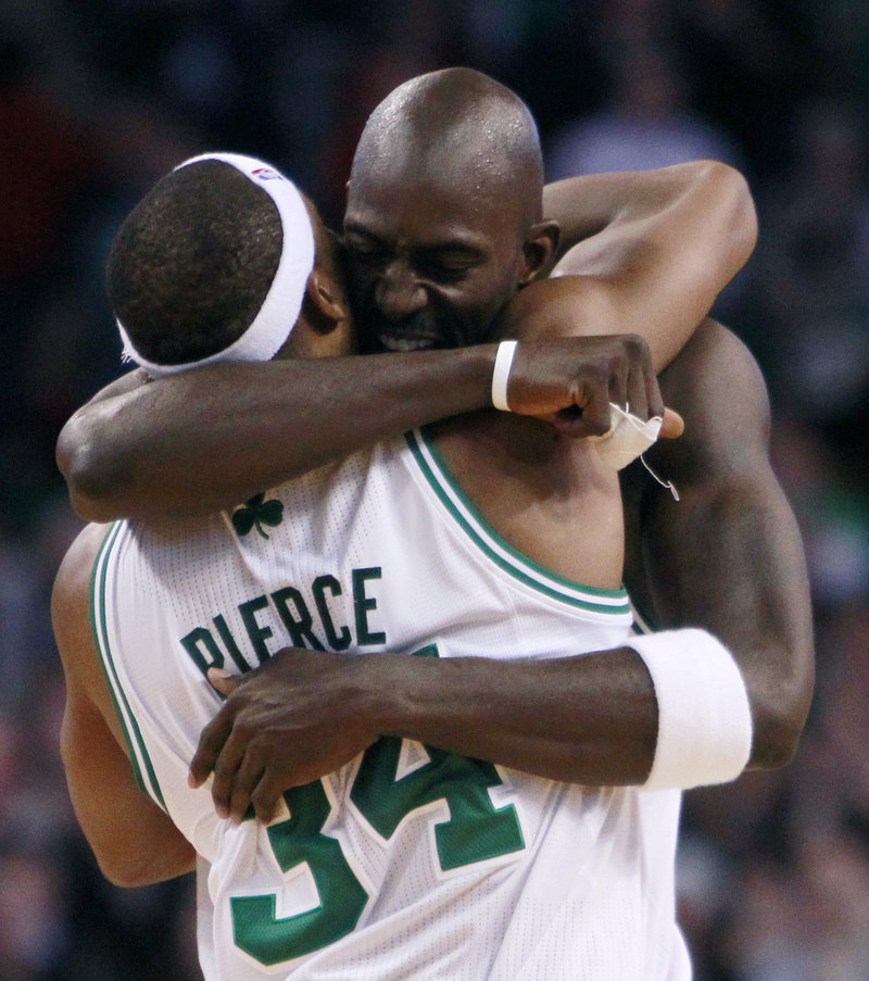 Kevin Garnett hugs Paul Pierce after the Celtics escaped with an 84-80 win over Philadelphia on Wednesday, extending Boston’s winning streak to 14 games.