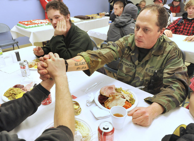 Scott McCracken joins hands in remembrance of friends with fellow veterans Nicholaus White and Joshua Lancaster.