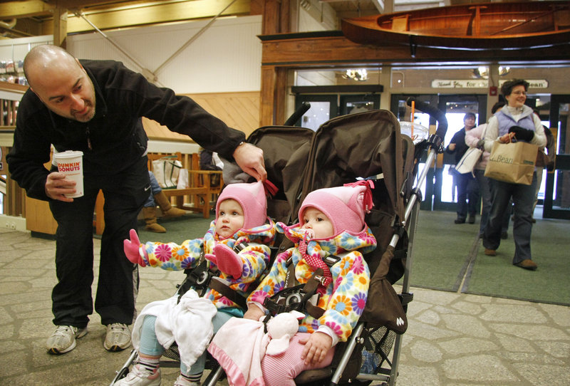 John Scalcione of South Carolina tends to his 18-month-old twins, Anna, left, and Ella, while shopping with his wife, Christina, at L.L. Bean in Freeport on Sunday.
