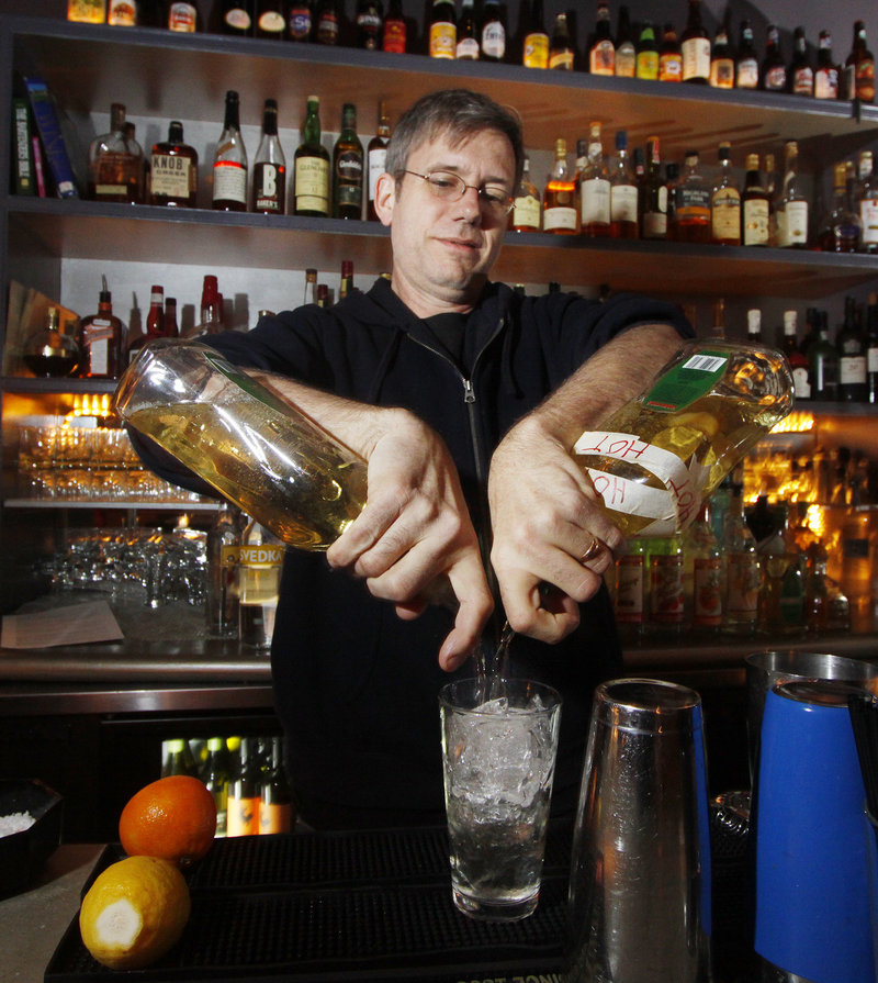 David Allen mixes a mojito at Bandaloop, where the bar area wraps around an exposed kitchen area.