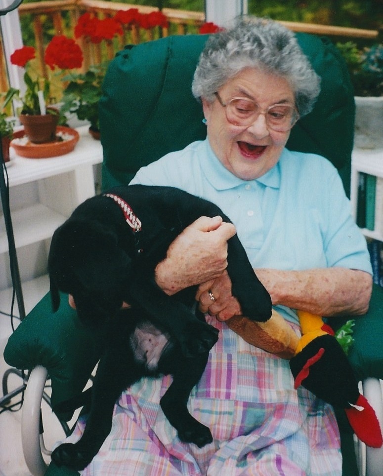 Julia Clarke holds her daughter Nancy Brewer's black Labrador retriever puppy.