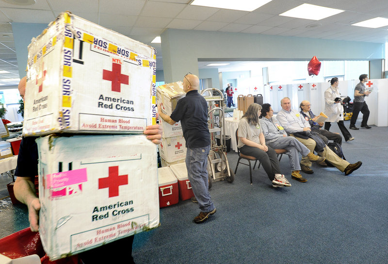 Workers distribute transport boxes as the first four donors wait their turn to give blood Thursday. The drive in Portland attracted some first-time donors, and others who had already given gallons.