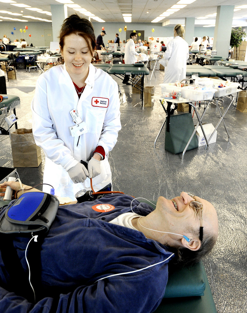 Collection specialist Dawn Holt draws blood from Maurice Harter of Portland. All donors were offered a gift bag with a T-shirt, a pound of Dunkin’ Donuts coffee and a fleece headband.