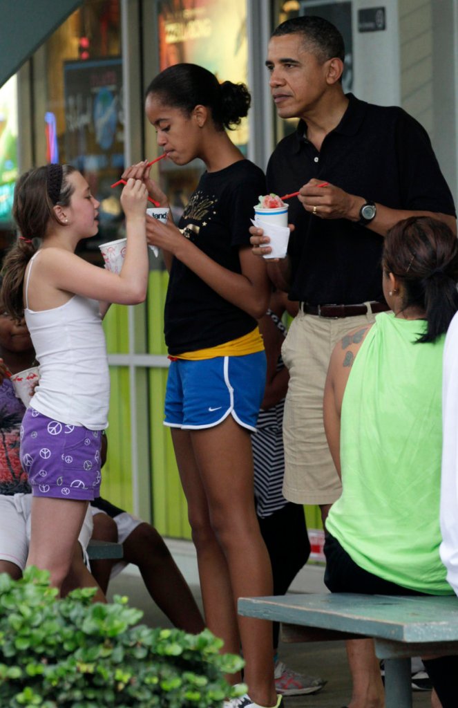 President Obama, his daughter Malia, second from left, and other family members and friends eat shave ice earlier this week at Island Snow at Kailua Beach Center while on vacation in Kailua, Hawaii.