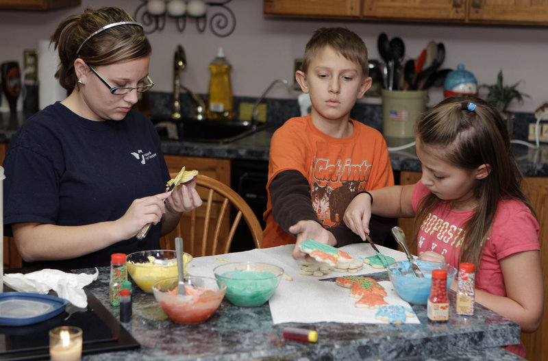 Tanner Hisey, center, puts icing on Christmas cookies with his sister Siera, right, and half-sister Tyler Smith in their home near Clyde, Ohio. Tanner, 12, and Tyler, 17, are among 35 children who live within a few miles of this small farming town and have been struck by cancer in the last decade.