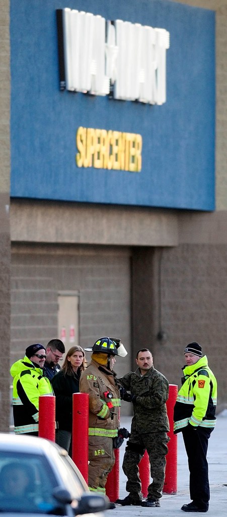 Three Augusta firefighters/paramedics and three unidentified people stand in front around 4 p.m. Thursday after the Augusta Walmart Supercenter was evacuated.