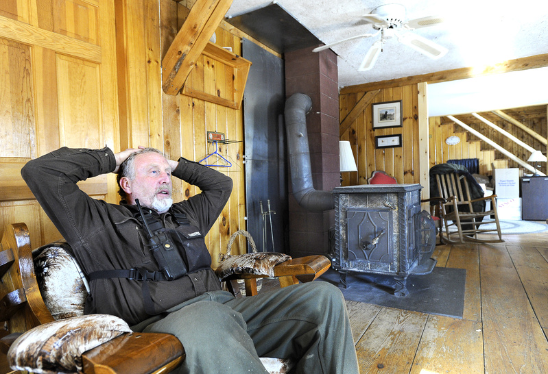 Greg Drummond sits by his wood stove at his Claybrook Mountain Lodge. He is among residents of Highland Plantation who oppose the wind power plan.