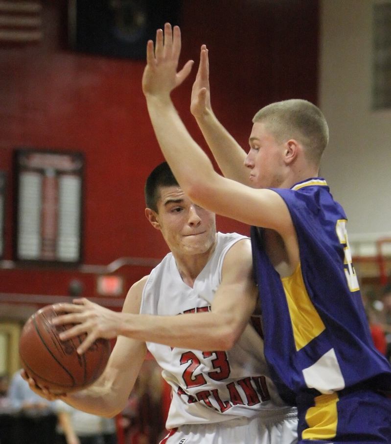 Vukasin Vignjevic of South Portland looks to pass Friday night while under pressure from Nick Burns of Cheverus during Cheverus 63-46 victory at Beal Gym in South Portland.