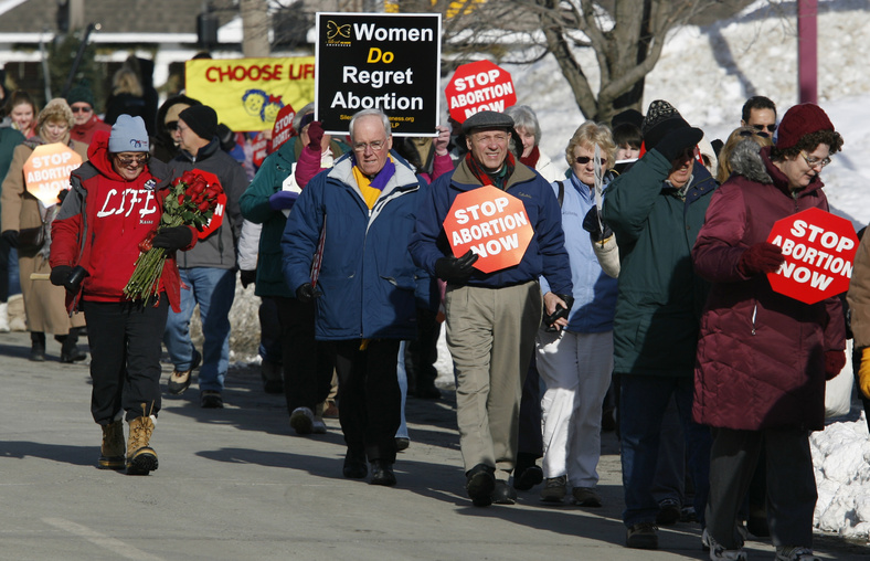 Participants in an anti-abortion rally march toward the State House Saturday in Augusta for the "Hands Around the Capitol" rally. The rally is held each year to recognize and mourn the anniversary of the Supreme Court's Roe vs. Wade decision.