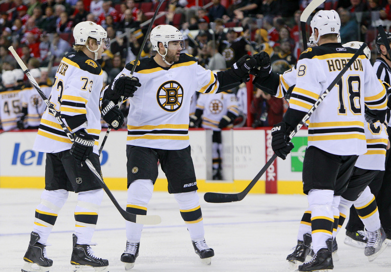Johnny Boychuk celebrates his goal against the Carolina Hurricanes with Michael Ryder, 73, and Nathan Horton, 18, in the first period Tuesday night in Raleigh, N.C. The Bruins won, 3-2.