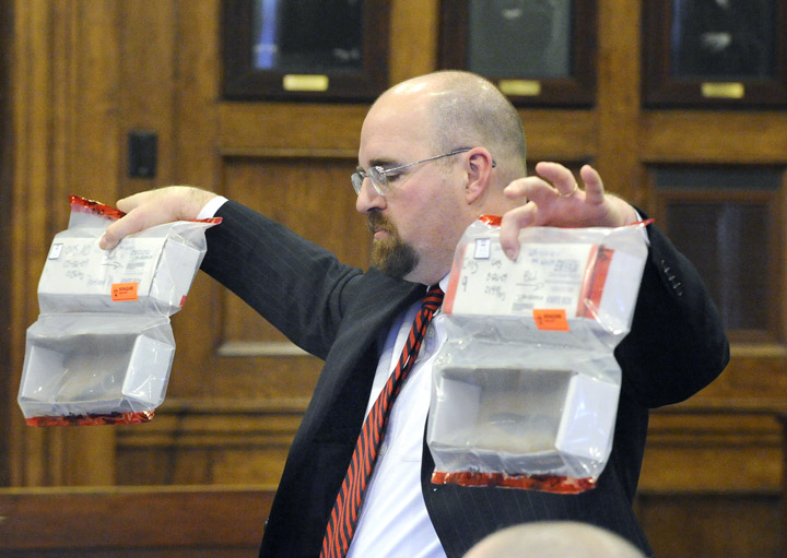 Assistant Attorney General Donald Macomber holds up two knives as evidence during his opening statement this morning in the trial of Chad Gurney.