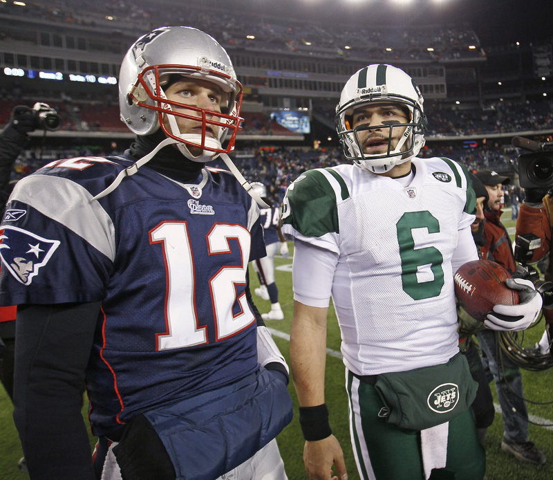 New England Patriots quarterback Tom Brady (12) and New York Jets quarterback Mark Sanchez (6) leave the field after the Jets beat the Patriots 28-21 in an NFL divisional playoff football game in Foxborough, Mass., Sunday.