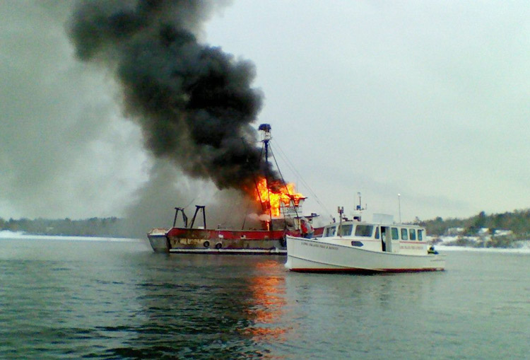 The 67-foot Deborah Lee burns at its mooring near Great Chebeague Island. Coast Guard crews and local responders are currently working to put out the fire and ensure there is no pollutioin. Photo by Coast Guard Station South Portland.