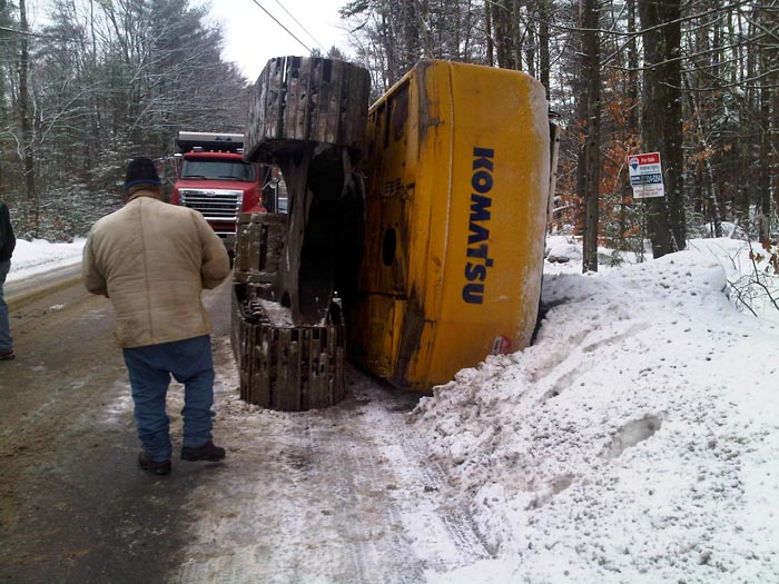 Upper Guinea Road in Lebanon was shut down for about 20 minutes Thursday morning after an excavator slid off a trailer and tipped over, landing on the side of the road.