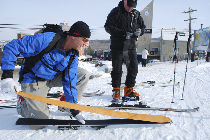 Cooper Friend affixes synthetic skins to skis before a training run with Warren Cook.