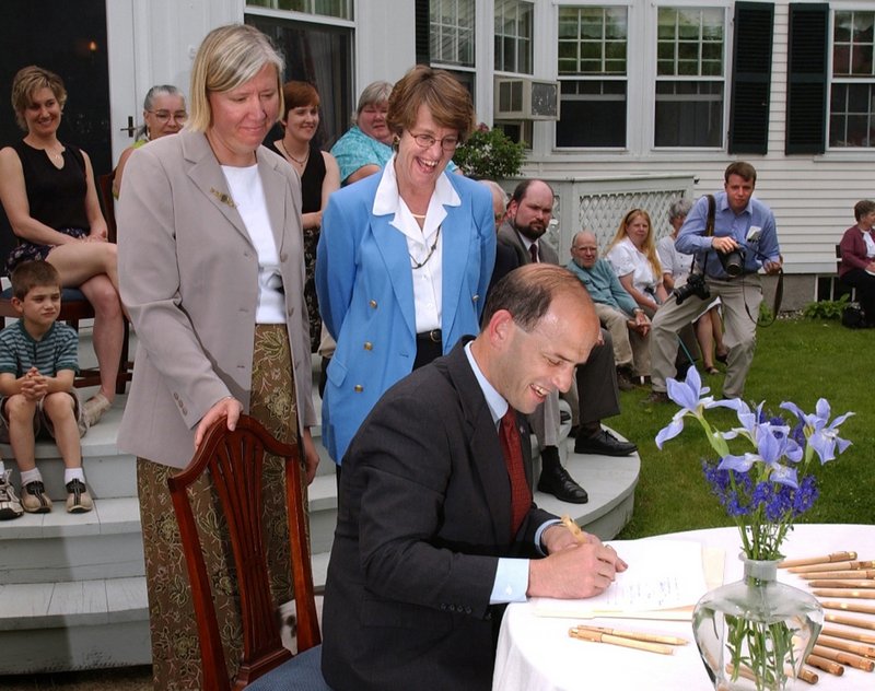 Gov. Baldacci signs the Dirigo Health bill on June 18, 2003, outside the Blaine House. With him are his wife, Karen Baldacci, left, and Trish Riley, director of the Governor’s Office of Health Policy and Finance.