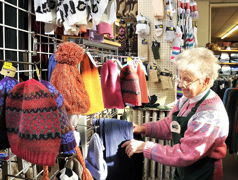 Dottie Hinds straightens items in the women’s clothing department at the Renys in Bath. She has been with the company for 14 years. “They are wonderful people to work with,” she said.