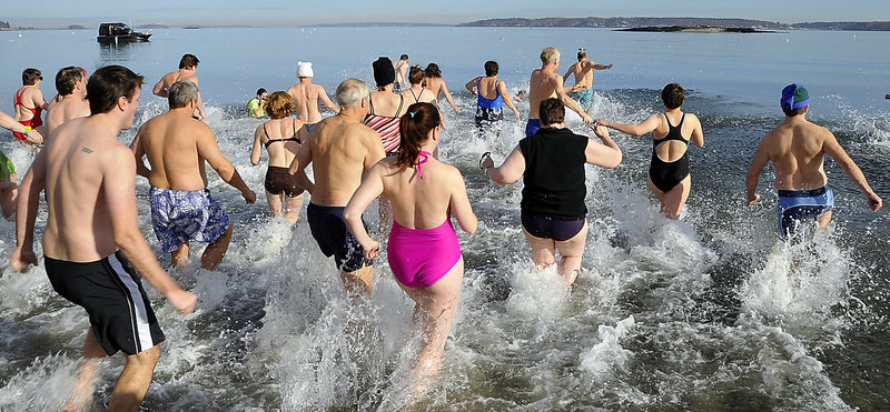 About 40 people race into the cold waters of Casco Bay for the Polar Plunge sponsored by the Natural Resources Council of Maine at East End Beach at noon Friday.