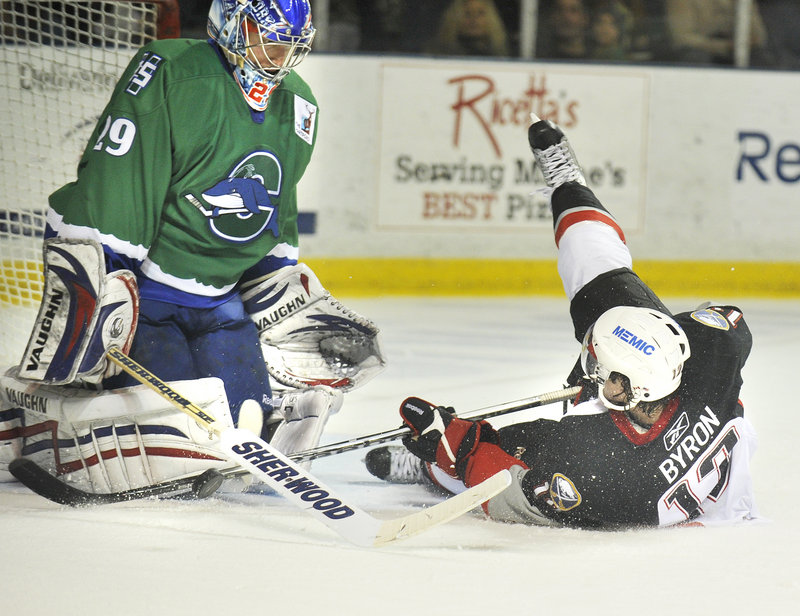 Paul Byron of the Portland Pirates slides into Connecticut goalie Chad Johnson after being taken down from behind on a breakaway Friday. Byron was given a penalty shot, which he converted. Connecticut won 5-4 in overtime at the Cumberland County Civic Center.