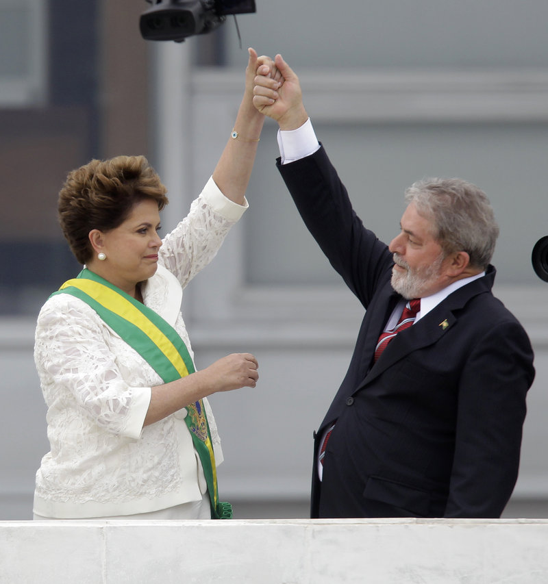 Brazil’s outgoing President Luiz Inacio Lula da Silva, right, raises the arm of President Dilma Rousseff, a former rebel, after placing the presidential sash on her at the Planalto palace in Brasilia, Brazil, on Saturday.